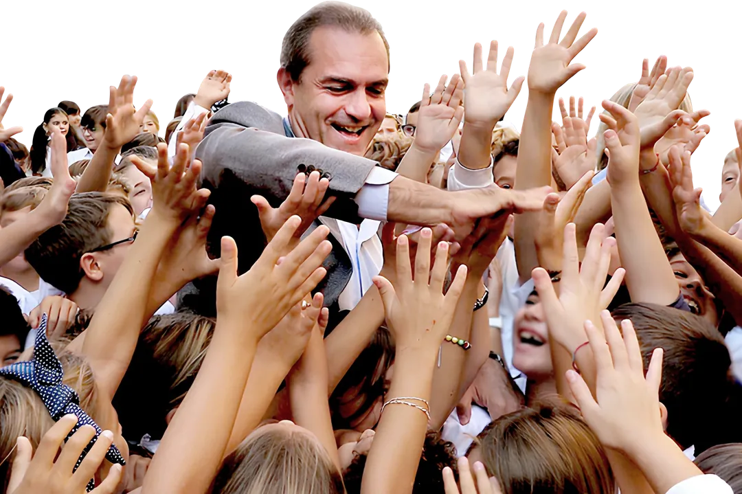 Luigi de Magistris in mezzo a tanti bambini con le mani alzate